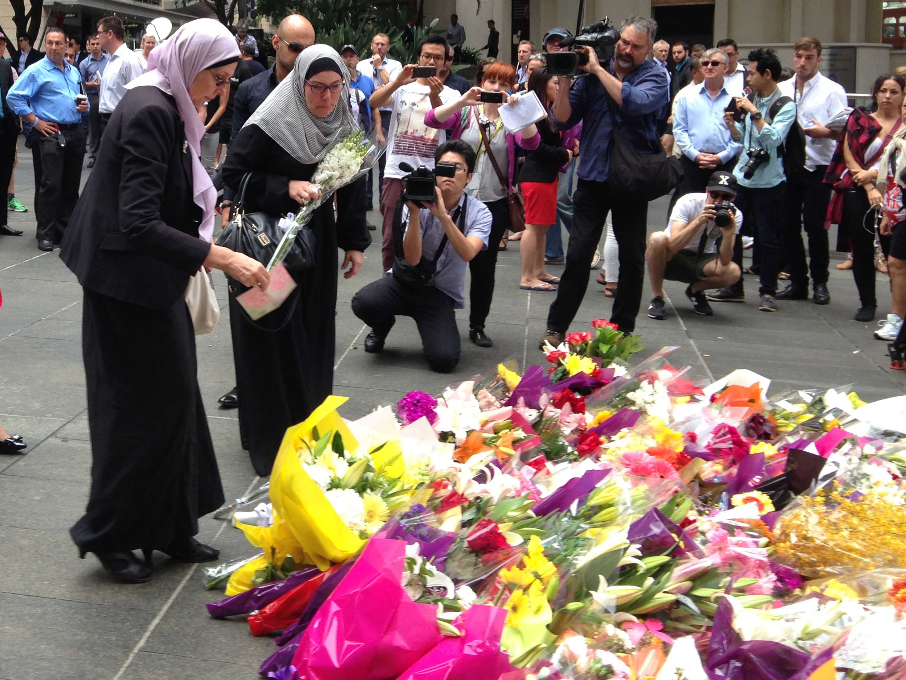 Women laying flowers at a memorial.