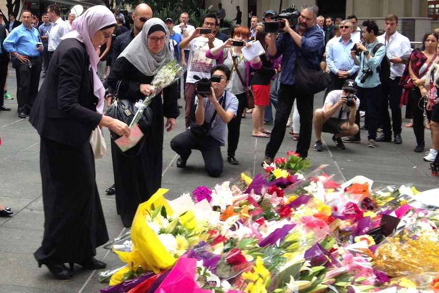 Women lay flowers at Martin Place