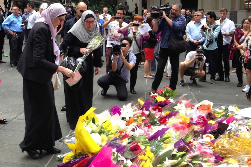 Two Muslim women lay flowers at a memorial in Sydney's Martin Place for the victims of the Lindt Cafe siege in December 2014.