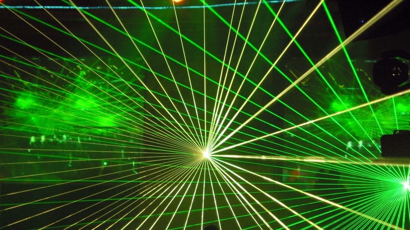 Laser lights pulsate at a rave party