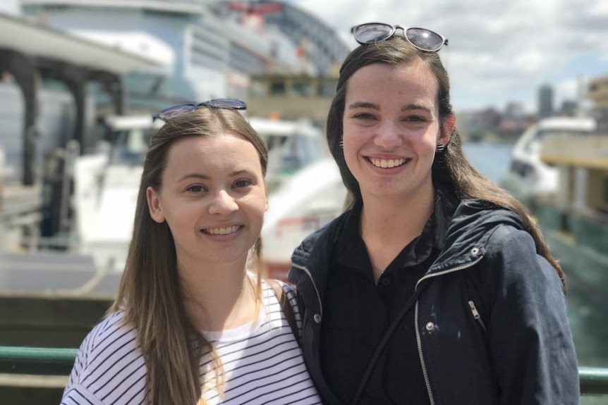 Two women look at the camera.