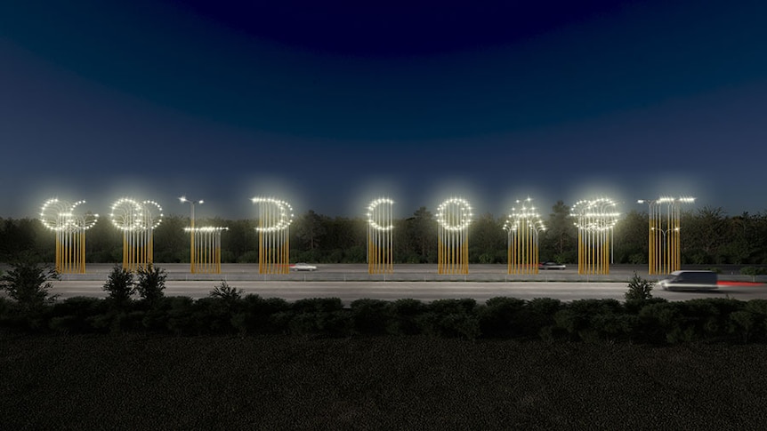 An artist's impression of a light installation spelling out "Gold Coast" by the side of the M1 as cars drive past at night.