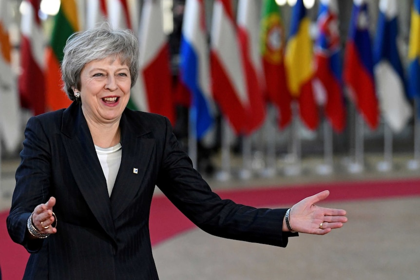 Theresa May with her hands out in front of her about to great an EU leader.