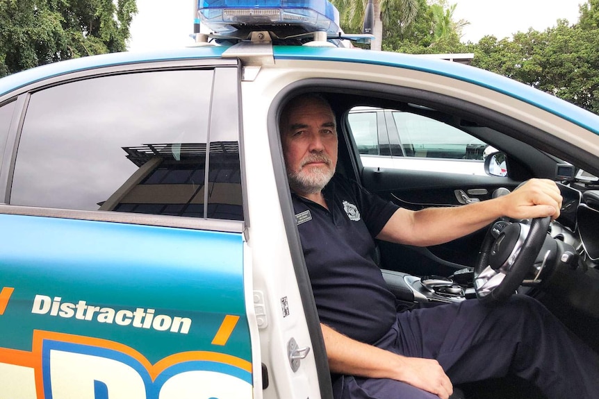 Queensland police Senior Sergeant Ian Crang sits behind the wheel of one of the Road Policing Command’s 'Fatal 5' cars.
