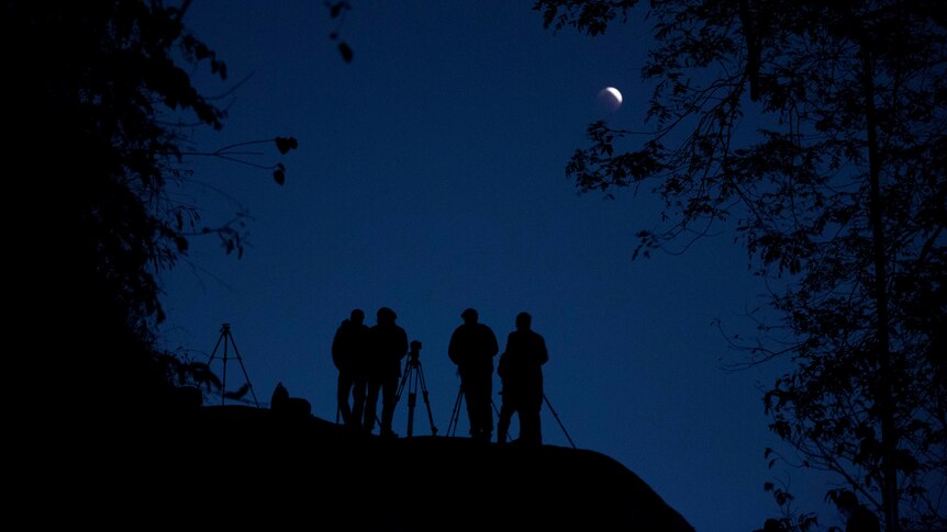 People use telescopes to observe the lunar eclipse in Gauhati, India.