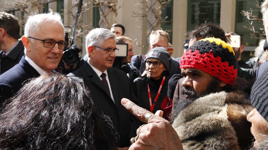 A woman points a finger at Malcolm Turnbull as he speaks with Clinton Pryor.