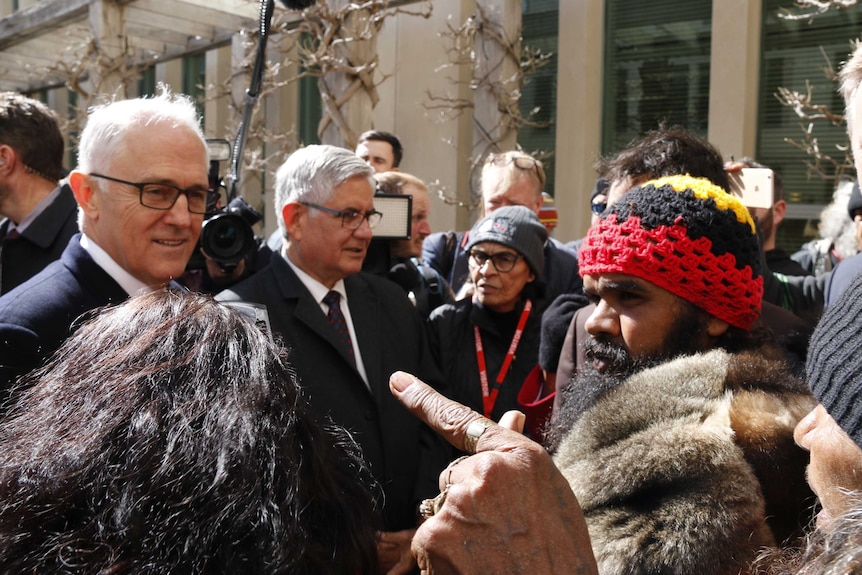 A woman points a finger at Malcolm Turnbull as he speaks with Clinton Pryor.