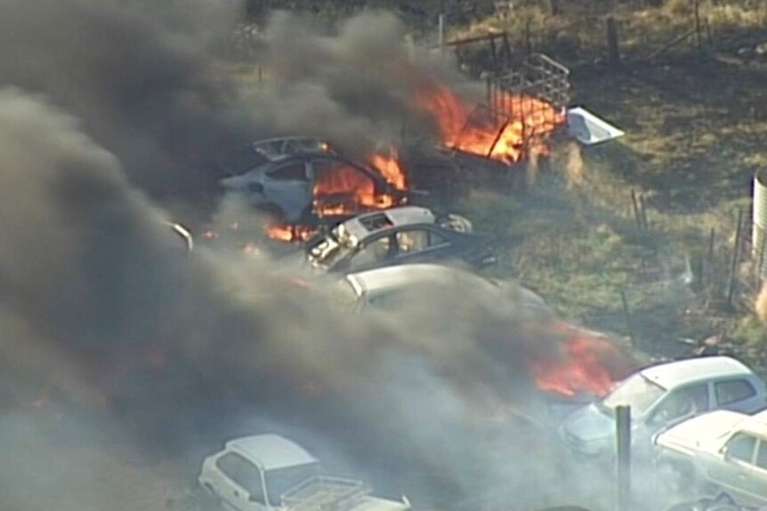 A number of cars on fire as seen from a helicopter.