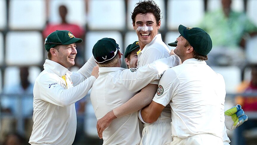 Mitchell Starc is congratulated by team-mates.