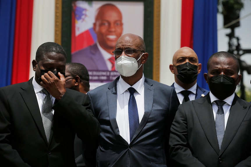 Haiti's Prime Minister Ariel Henry poses for a group photo in front of a portrait of the slain president Jovenel Moise