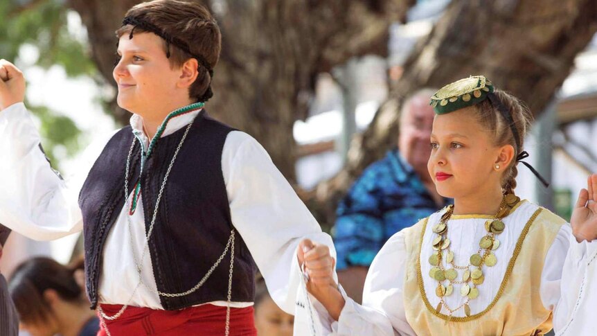 Close up photography of two young kids in traditional Greek costumes.