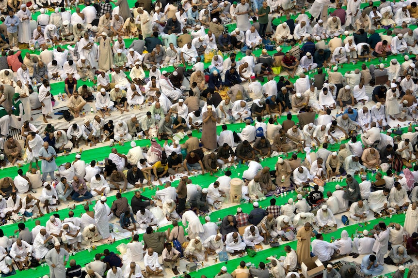 Rows of Muslim worshippers at the Grand Mosque in Mecca seated before food and drink they will consume after sunset.