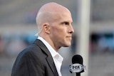 Grant Wahl holds a Fox Sports microphone.