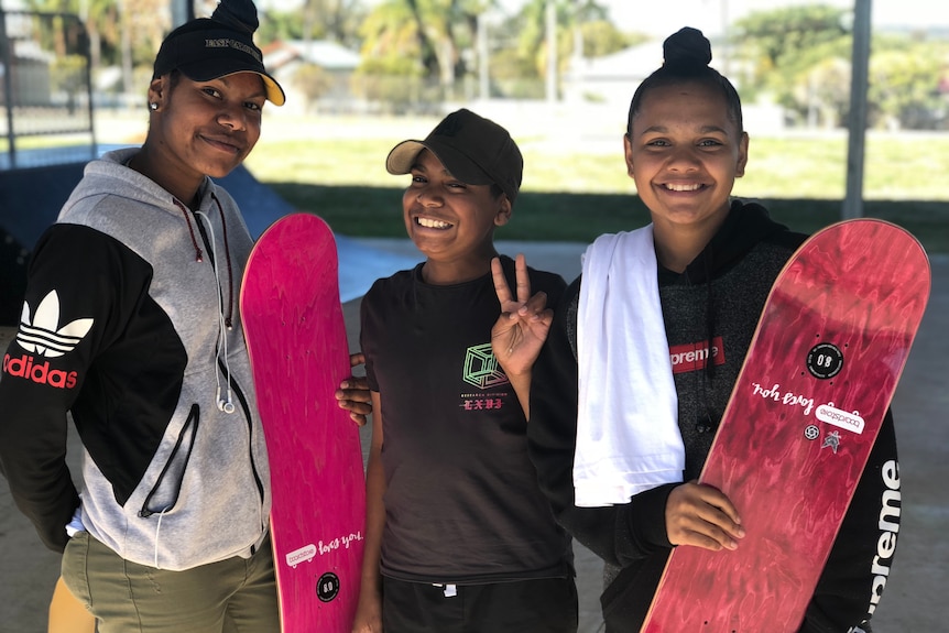 Three teens in Murgon, Queensland, at a skate park with their skateboards.