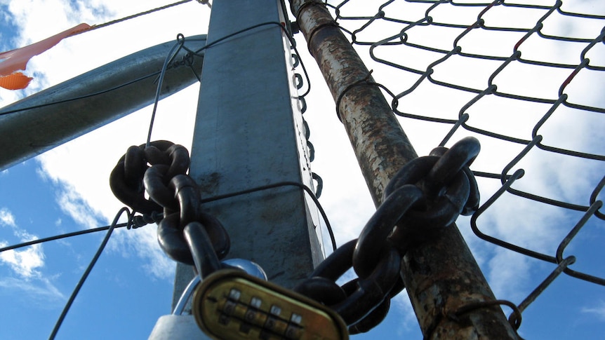 A lock at the gates of Pontville Defence Force site in Hobart where a detention centre will be set u