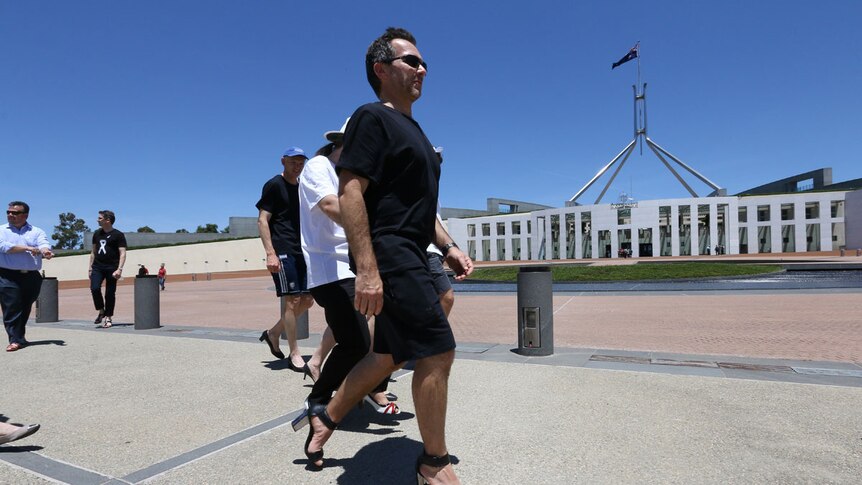 Men walk in high heels outside Parliament House for White Ribbon Day