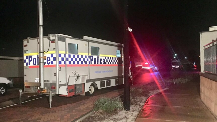A WA Police forward command vehicle sits parked on the side of a suburban road in Ellenbrook at night.