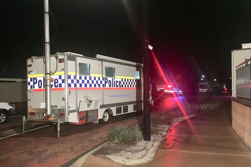 A WA Police forward command vehicle sits parked on the side of a suburban road in Ellenbrook at night.