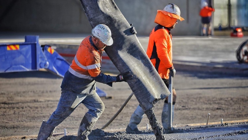 worksite showing a construction worker pouring cement
