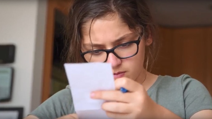 A girl looks at a receipt.