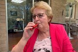 Dianne Gorman holds an e-cigarette to her lips.