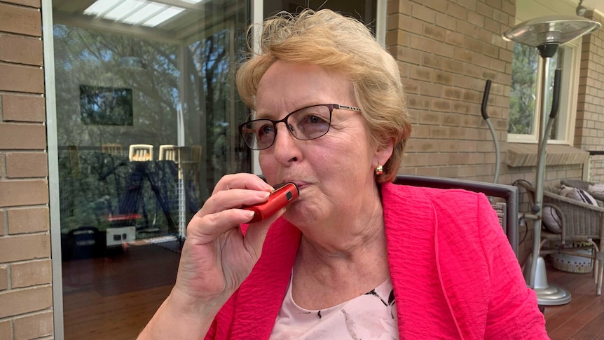 Dianne Gorman holds an e-cigarette to her lips.
