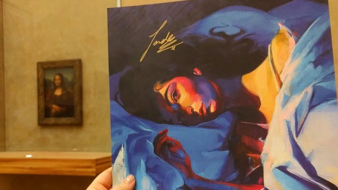 A vinyl copy of Lorde's 'Melodrama' held up with the Mona Lisa in sight behind it