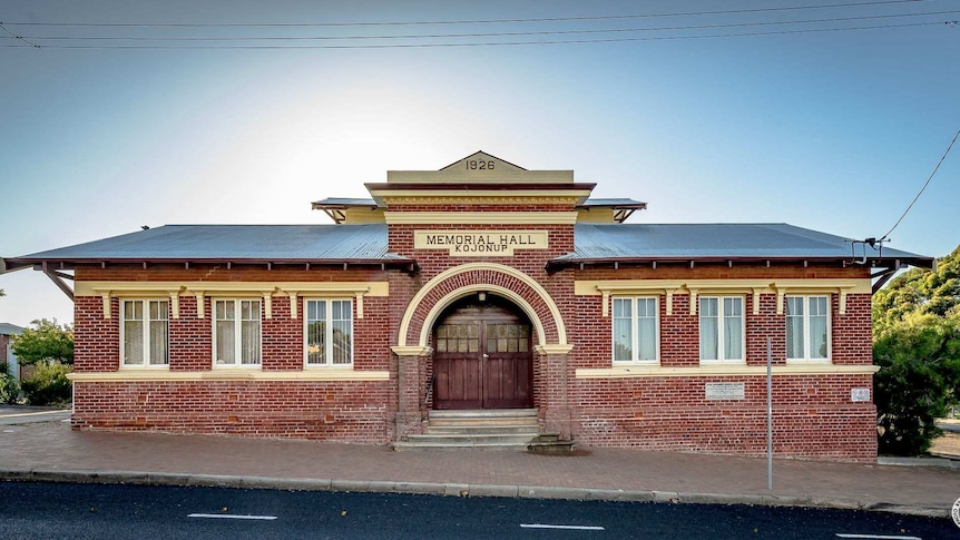 An old red brick building on the side of a street