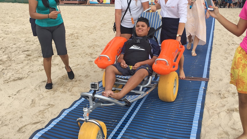 Muzaffar Deen, who has muscular dystrophy, on the beach in his wheelchair