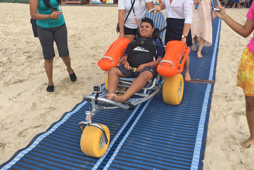 Muzaffar Deen, who has muscular dystrophy, on the beach in his wheelchair