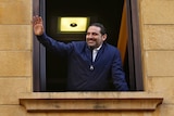 Saad Hariri waves to his supporters from a window of his residence.