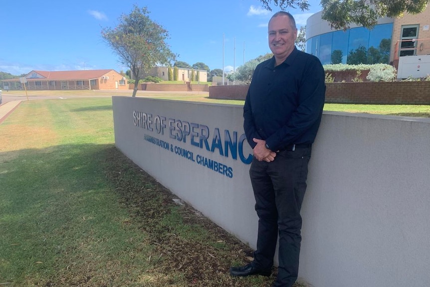 A man stands near the Shire of Esperance sign