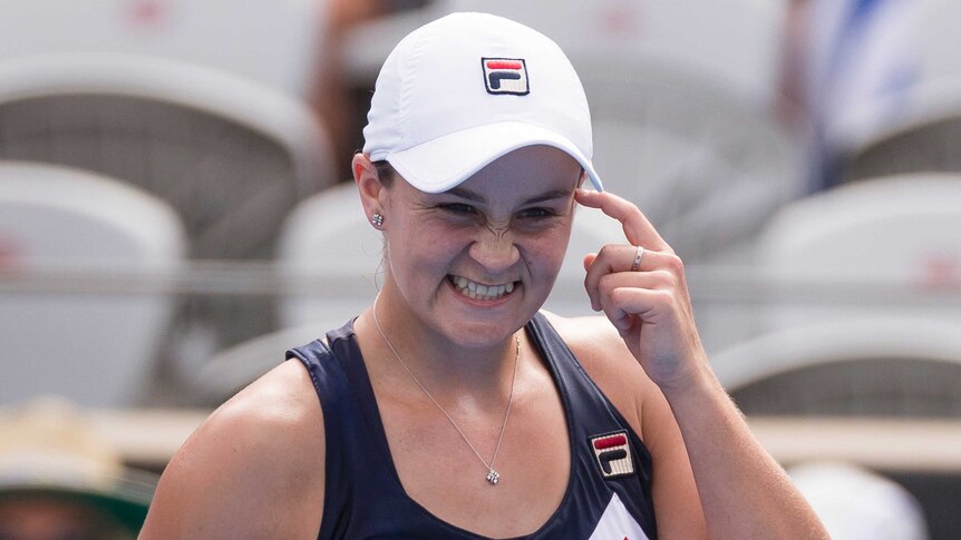 Ashleigh Barty points to her head as she celebrates her win over Simona Halep at the Sydney International on January 9, 2019.