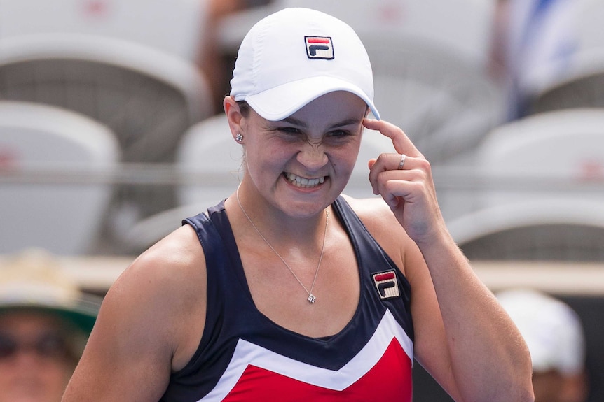 Ashleigh Barty points to her head as she celebrates her win over Simona Halep at the Sydney International on January 9, 2019.