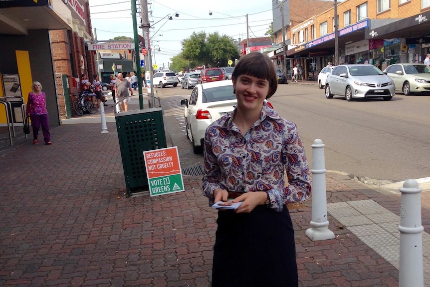 A woman stands on a foorpath.