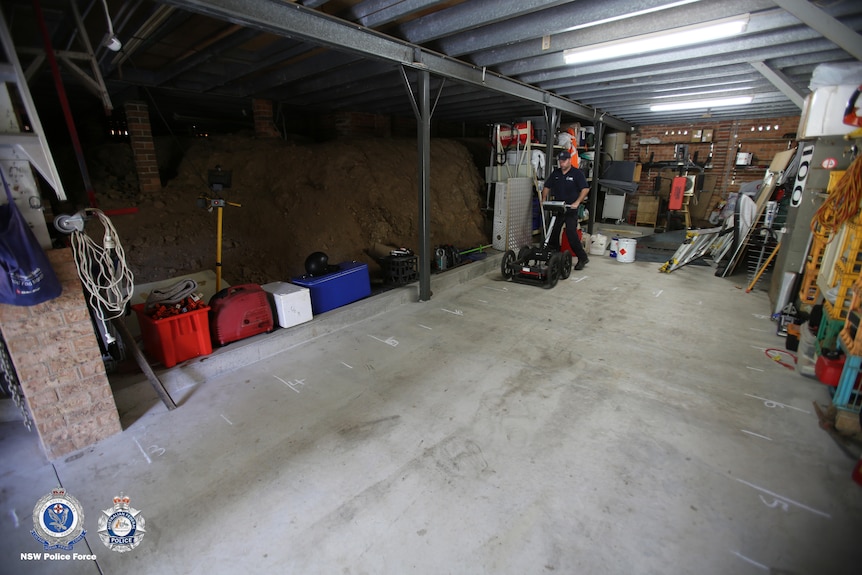 a police man using a machine inside  a garage