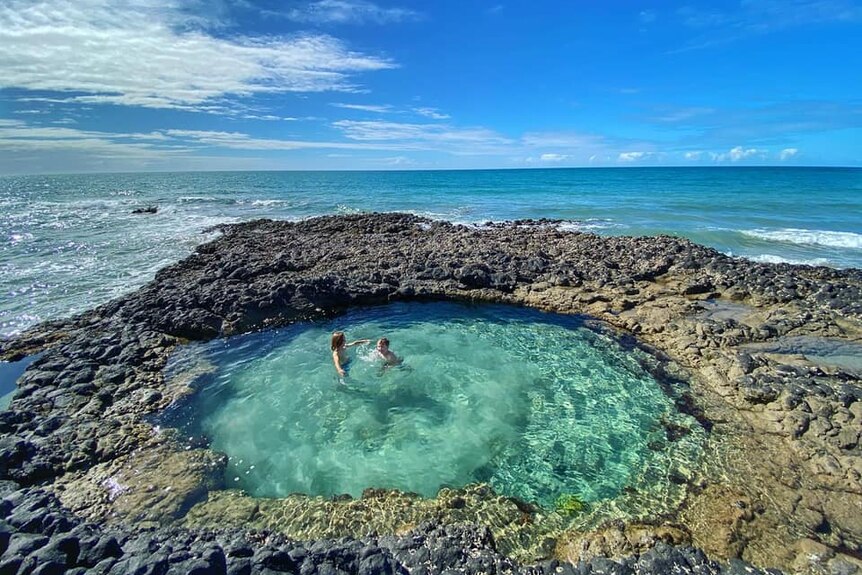 Round sea pool surrounded by ocean.