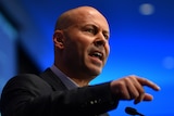 Australian Treasurer Josh Frydenberg speaks at a campaign launch against a blue backdrop.