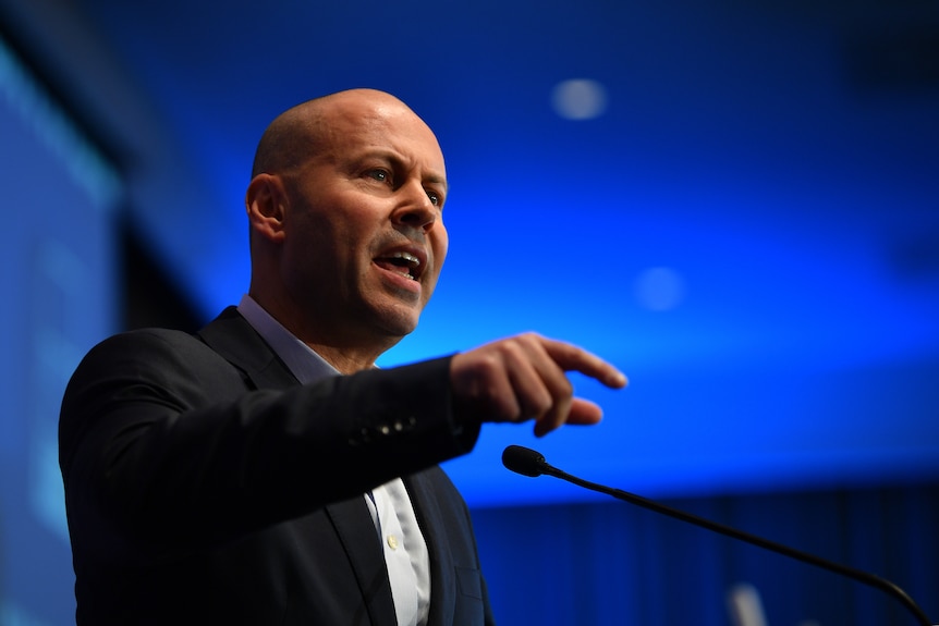 Australian Treasurer Josh Frydenberg speaks at a campaign launch against a blue backdrop.