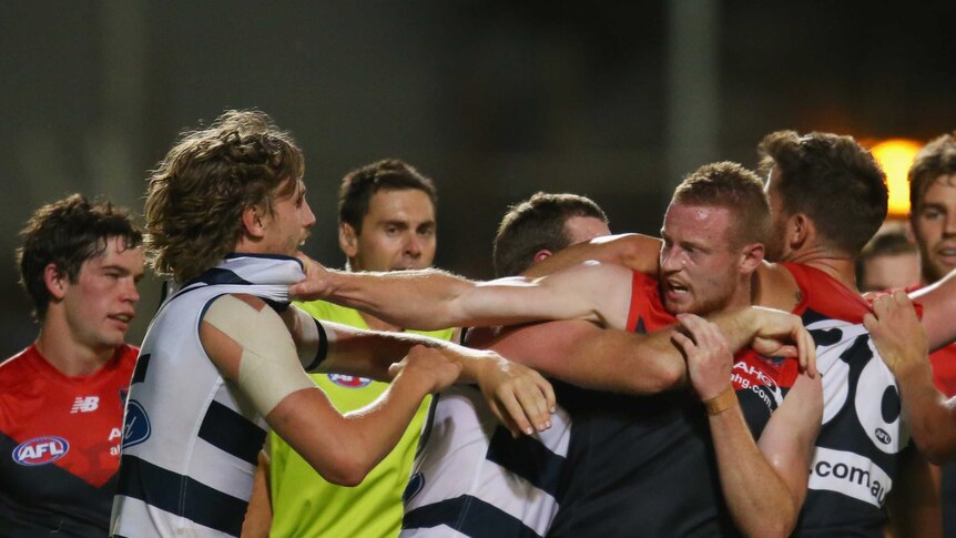 Geelong and Melbourne players wrestle in their preseason clash