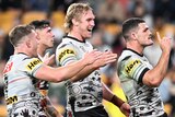 Three Penrith NRL players celebrate a try against the Broncos.