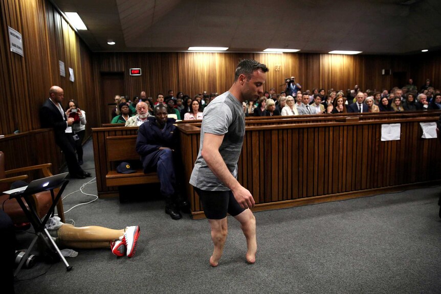 Oscar Pistorius walks across the courtroom without his prosthetic legs