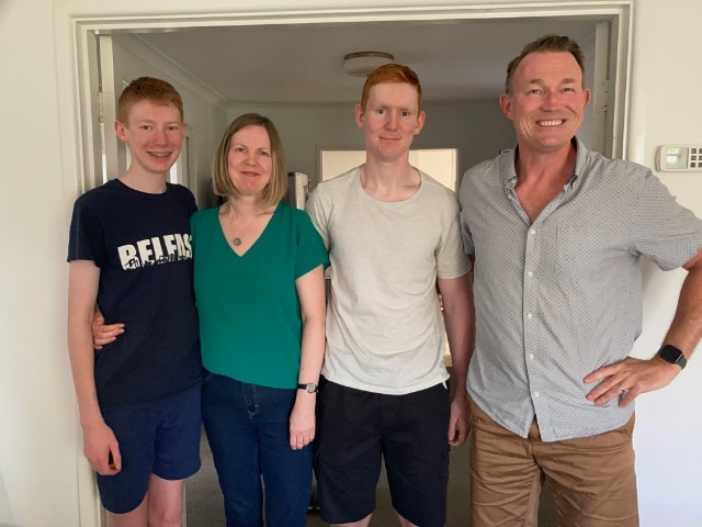 Matthew, Joe, Amanda y Tom están en fila, sonriendo.