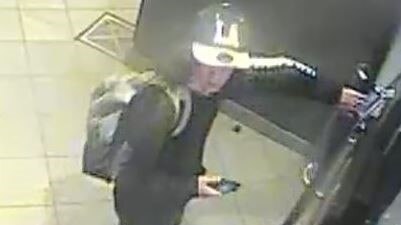 A teenager pictured on CCTV wearing a baseball cap and a backpack.