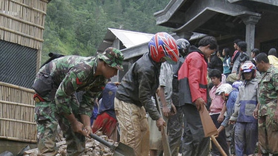 Indonesian soldiers and villagers dig into mud to search for landslide victims in Karang Anyar district near Solo, Indonesia's Central Java province.