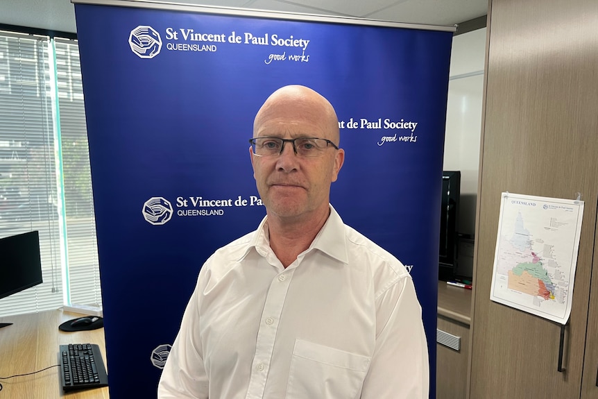 man with glasses stands in front of st vincent de paul banner