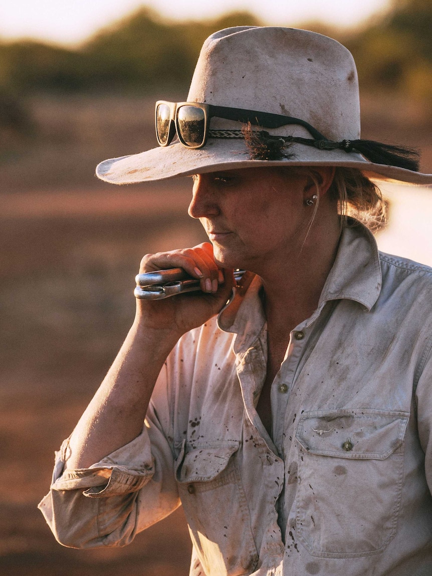 A woman wearing a hat at last light