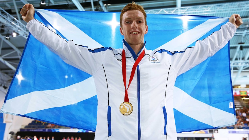 Daniel Wallace poses with Scottish flag after winning the men's 400m individual medley in Glasgow.