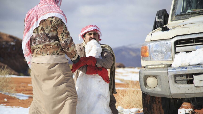 Men make snowman in Saudi Arabia