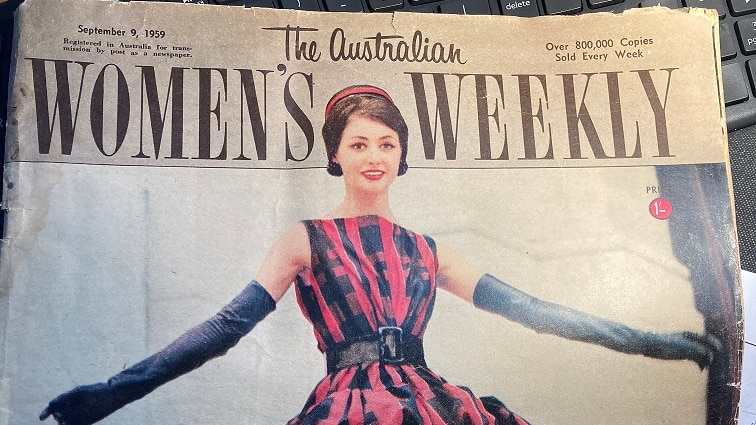 A magazine cover features a woman wearing Dior couture, a ruffled pink and navy dress with long gloves.
